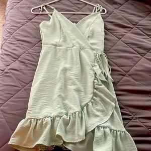 A green colored dress,fake bow tie in the front,zips up in the back